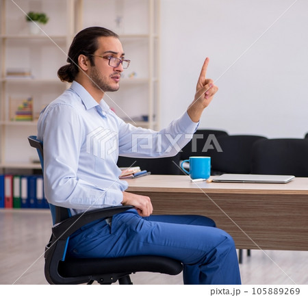 Young male boss giving seminar in the office during pandemic 105889269