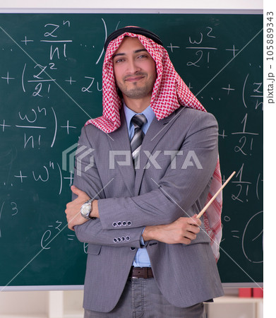 Arab teacher wearing suit in front of chalkboard Arab teacher wearing suit in front of chalkboard 105889343