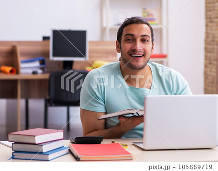 Young male student preparing for exams at home in tele-education 105889719