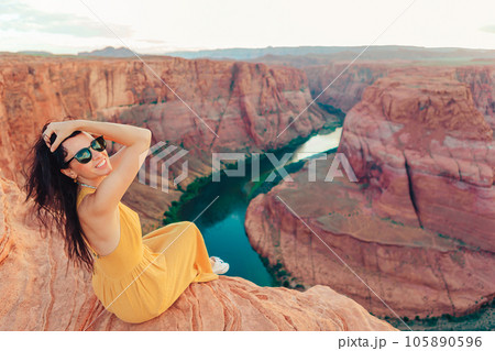 Beautiful woman in yellow dress on the edge of the cliff at Horseshoe Band Canyon in Paje, Arizona. Beautiful nature in USA 105890596
