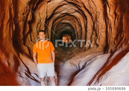 Young hiker man on popular trail Belly of the Dragon Tunnel Cave in Kanab Young hiker man on popular trail Belly of the Dragon Tunnel Cave in Kanab 105890686