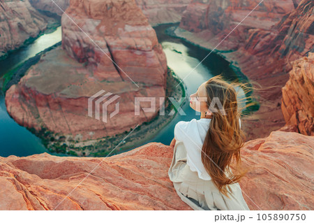 Happy girl on the edge of the cliff at Horseshoe Band Canyon in Paje, Arizona. Adventure and tourism concept. Beautiful nature in USA Happy girl on the edge of the cliff at Horseshoe Band Canyon in Paje, Arizona. Adventure and tourism concept. Beautiful nature in USA 105890750