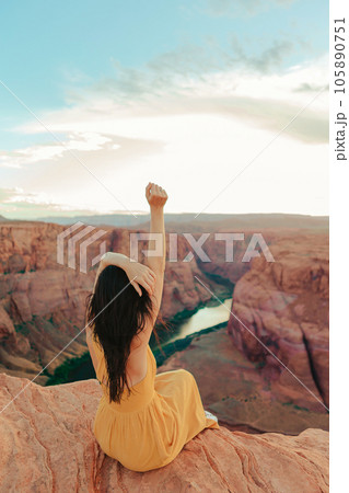 Beautiful woman in yellow dress on the edge of the cliff at Horseshoe Band Canyon in Paje, Arizona. Beautiful nature in USA Beautiful woman in yellow dress on the edge of the cliff at Horseshoe Band Canyon in Paje, Arizona. Beautiful nature in USA 105890751