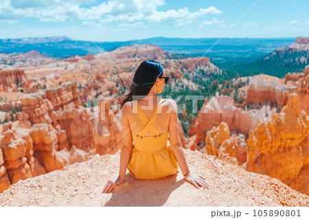 Hiker woman in Bryce Canyon resting enjoying view in beautiful nature landscape with hoodoos, pinnacles and spires rock formations in Utah 105890801
