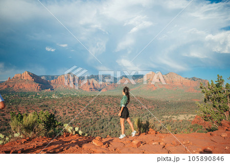 Young hiker woman on the edge of a cliff at Cathedral Rock in Sedona, Arizona. View from Scenic Cathedral Rock in Sedona with blue sky in Arizona 105890846
