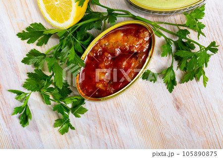 Tasty cod in tomato sauce on background with greens and lemon 105890875