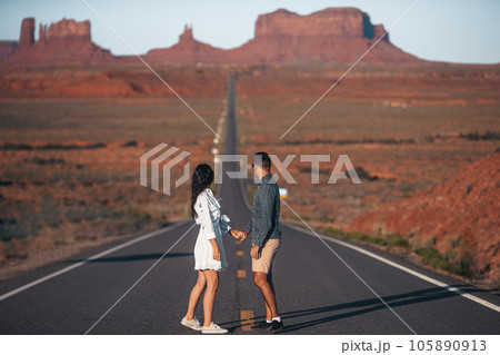 Happy couple on the famous road to Monument Valley in Utah. Amazing view of the Monument valley. 105890913