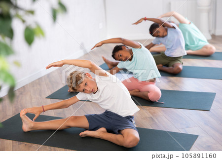 School kids training during yoga class on yoga mats. 105891160