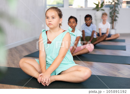 Training yoga kids on yoga mat in gym. 105891192