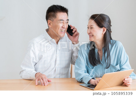 パソコンとスマホを使うシニア夫婦 パソコンとスマホを使うシニア夫婦 105895339