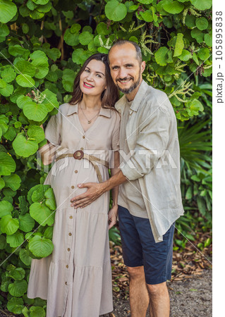 A blissful scene in the park as a radiant pregnant woman after 40 and her loving husband after 40, cherish the joy of parenthood together, surrounded by nature's serenity 105895838