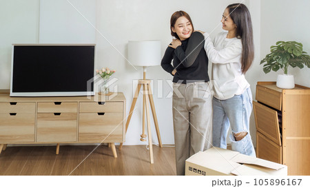 Young woman lesbian couple moving to a new home and girlfriend massaging her shoulders from the lift the box for move to new home Young woman lesbian couple moving to a new home and girlfriend massaging her shoulders from the lift the box for move to new home 105896167