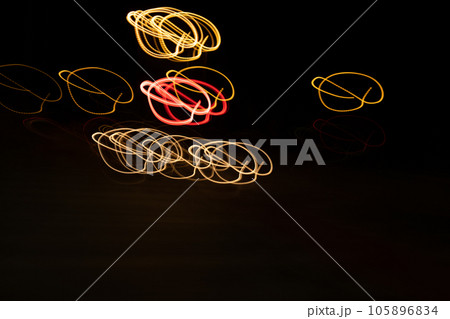 Long exposure, light painting photography, multi color swirl effect against black background. Night city lights  105896834