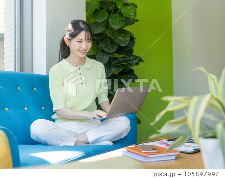 ソファに座ってパソコンを操作する若い女性 105897992