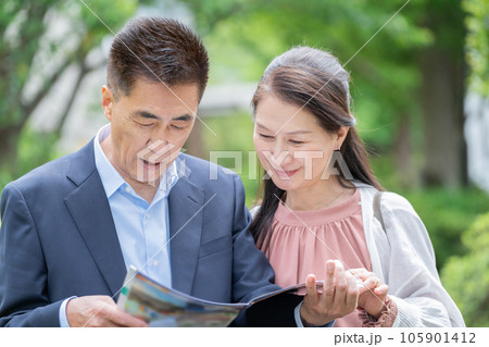 パンフレットを見るシニア夫婦 105901412