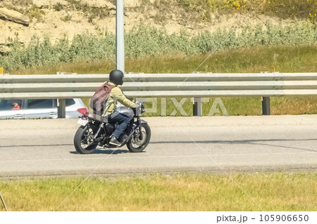 Calgary, AB, Canada. Aug 13 ,2023. A person driving a motorcycle on a highway during summer. 105906650