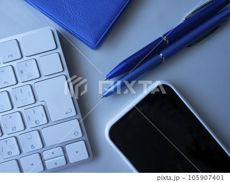テーブルに置かれた手帳とキーボードとスマートフォン 105907401