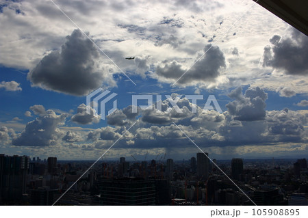 Dramatic clouds in the late afternoon above Tokyo Japan with a plane flying overhead 105908895