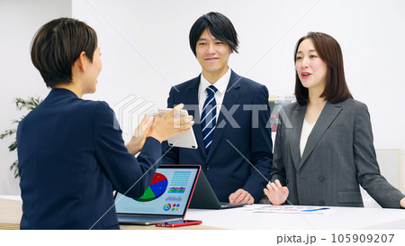 電卓を見せて説明する女性セールスパーソン 105909207