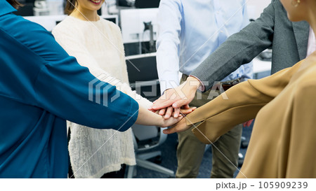 オフィスで円陣を組むカジュアルなビジネスパーソンのグループ 105909239