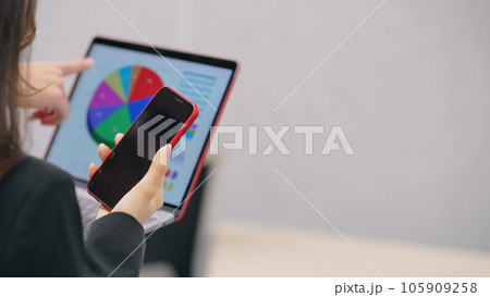 スマホとノートパソコンを持って会話するビジネスパーソンのグループ 105909258