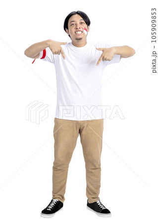 Indonesian man celebrates Indonesian independence day on 17 August while pointing to something 105909853