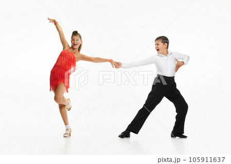 Boy and girl, children, friends making beautiful performance, dancing retro dance styles against white studio background 105911637