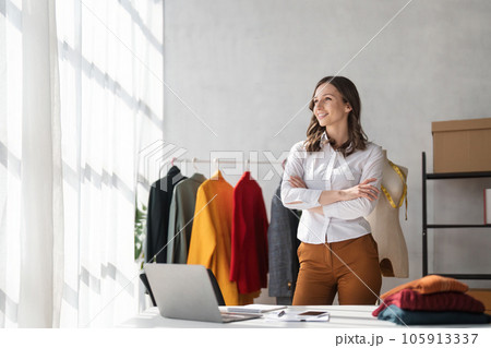 Attractive young woman smiles. Portrait of fashion designer in office Attractive young woman smiles. Portrait of fashion designer in office 105913337