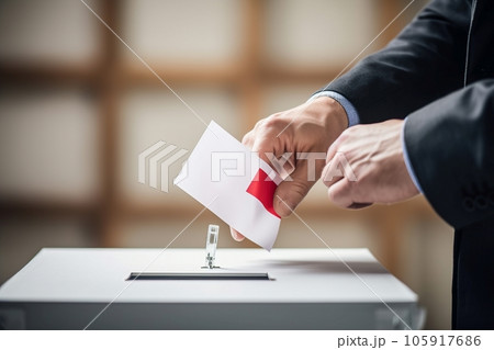 Man casts his vote into a voting urn. In the background, Polish flags 105917686