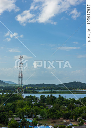 a telephone tower aerial photo shows a cell tower for a mobile phone over a rural, forested area in Thailand. 105917957