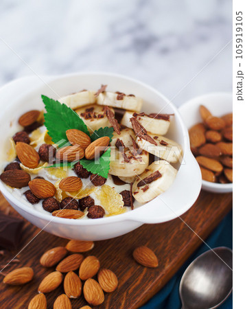 Almond banana salad with chocolate and milk in white plate. Healthy nutritious breakfast. Top view Almond banana salad with chocolate and milk in white plate. Healthy nutritious breakfast. Top view 105919105