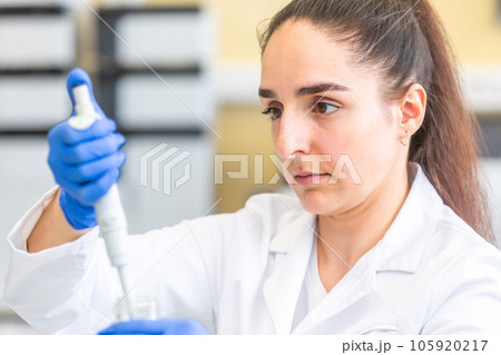 Young woman scientist in a research laboratory creating a scientific experiment, laboratory concept 105920217