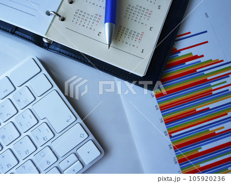 テーブルに置かれたカレンダー、キーボード、グラフ 105920236