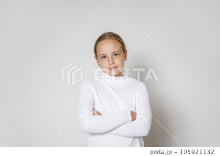 Portrait of child with crossed arms on white background. Young girl 10 years old, studio portrait 105921132