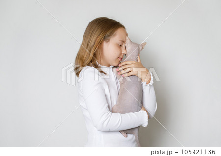 Kid holding sphinx cat pet on white background 105921136