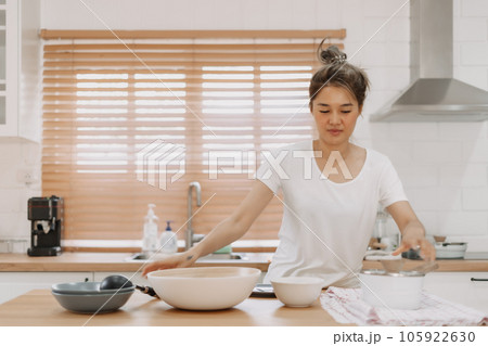 Woman checking out the food she made in the kitchen. Woman checking out the food she made in the kitchen. 105922630