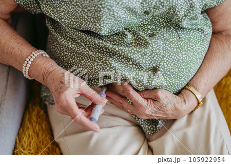 Diabetic senior patient injecting insulin in her belly. Diabetic senior patient injecting insulin in her belly. 105922954