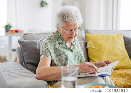 Diabetic senior patient using continuous glucose monitor to check blood sugar level at home. 105922959