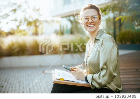 happy business woman in green blouse and eyeglasses 105923489