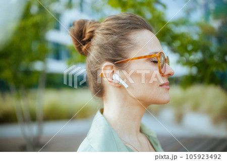 relaxed modern female employee in green blouse and eyeglasses 105923492