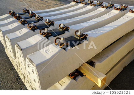 Before installation stacked new reinforced concrete railroad track sleepers with rail mounts Before installation stacked new reinforced concrete railroad track sleepers with rail mounts 105923525