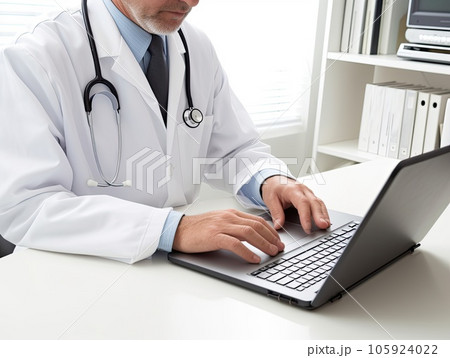 Closeup picture of a doctor typing on laptop in his clinic office 105924022