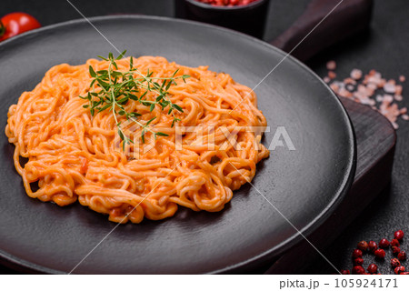 Delicious fresh pasta consisting of thin noodles, red pesto rosso sauce with spices and herbs Delicious fresh pasta consisting of thin noodles, red pesto rosso sauce with spices and herbs 105924171