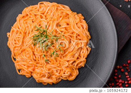 Delicious fresh pasta consisting of thin noodles, red pesto rosso sauce with spices and herbs 105924172