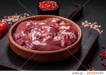 Fresh raw chicken or turkey liver in a ceramic plate with salt, spices and herbs 105924204