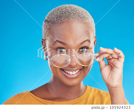 Happy, portrait and black woman with glasses on a blue background for stylish, trendy and fashion. Cool, smile and headshot of an African girl or optometry model with eyewear for vision and eye care Happy, portrait and black woman with glasses on a blue background for stylish, trendy and fashion. Cool, smile and headshot of an African girl or optometry model with eyewear for vision and eye care 105924323