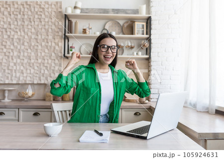 Portrait of a young business woman, a freelancer who rejoices at the finished successful project, looks at the camera and rejoices at the success. Portrait of a young business woman, a freelancer who rejoices at the finished successful project, looks at the camera and rejoices at the success. 105924631