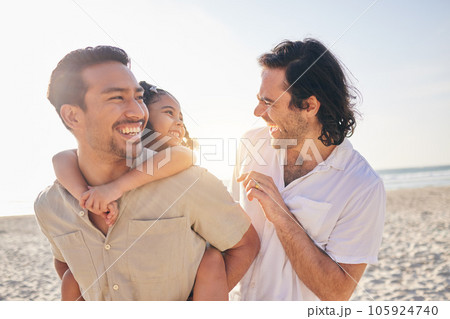 Happy, piggyback and lgbt family at the beach for love, care and a vacation in summer. Smile, nature and gay parents laughing with a child at the sea during a holiday for bonding, comedy or travel 105924740