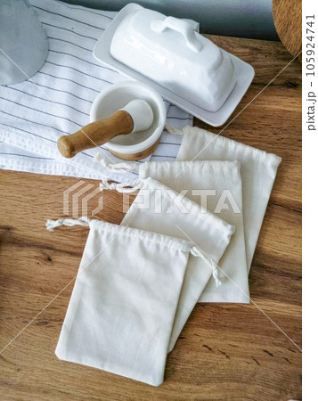 White cotton bags and utensils on a wooden table. Fabric bag mockup 105924741