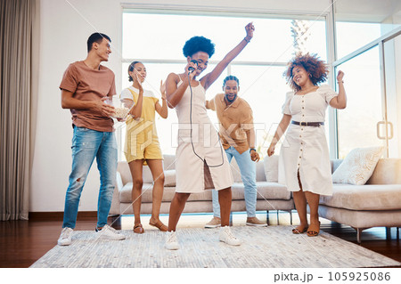 Sing, energy and friends dancing in the living room with a microphone to music, playlist or radio. Happy, diversity and young people moving, bonding and having fun together with karaoke at home. Sing, energy and friends dancing in the living room with a microphone to music, playlist or radio. Happy, diversity and young people moving, bonding and having fun together with karaoke at home. 105925086